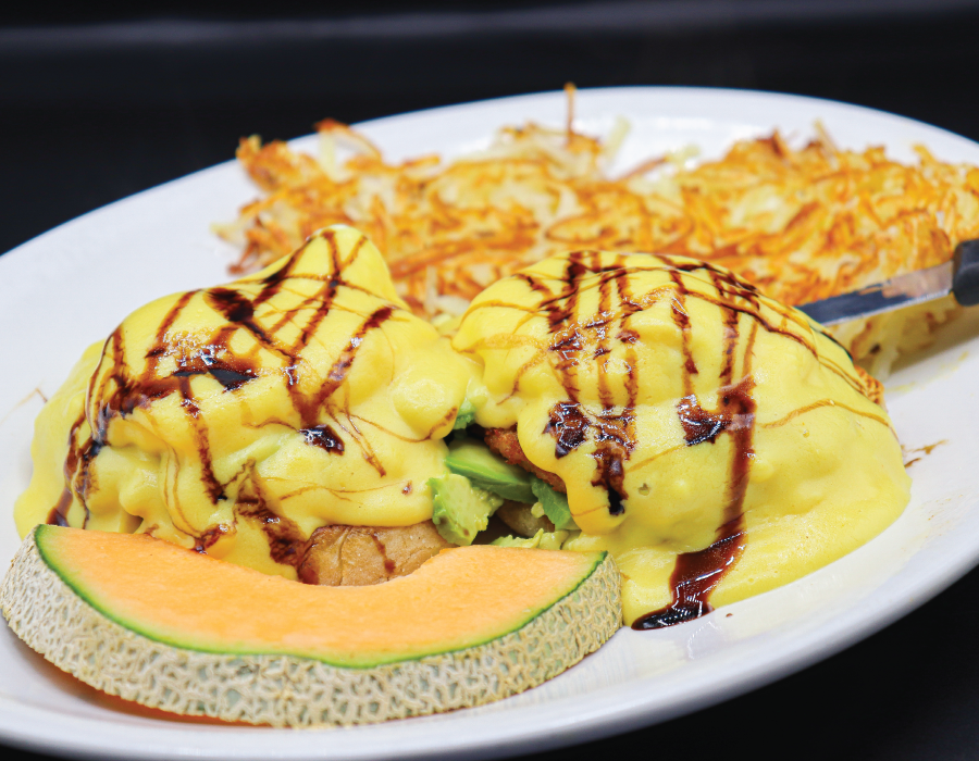 Two poached eggs* atop fried green tomatoes, avocado and an english muffin. Topped with hollandaise with a balsamic glaze drizzle at Jacks Coffee House.